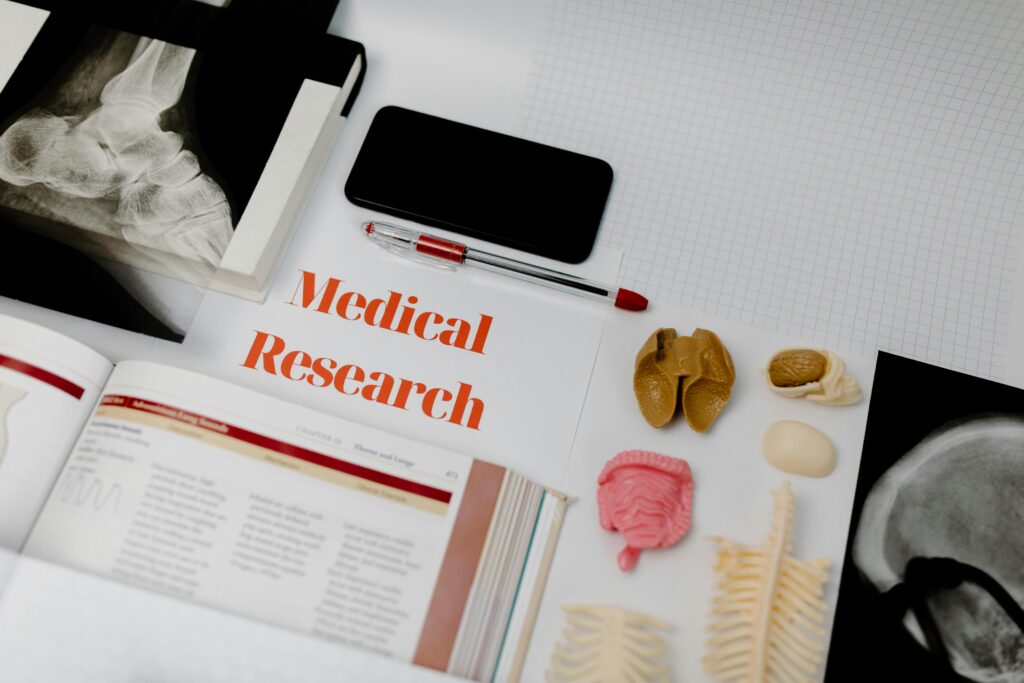 Medical research setup featuring anatomical models, x-rays, and a textbook, ideal for educational purposes.